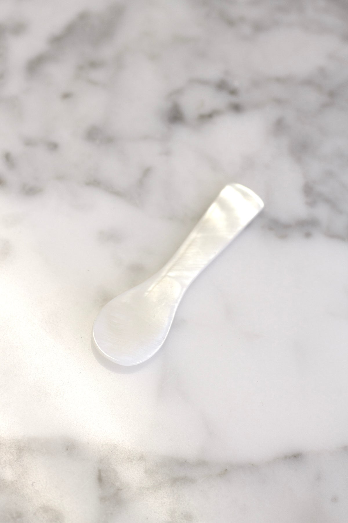 Mother of pearl spoon on white marble