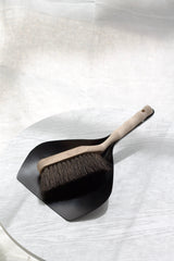 Dustpan and brush set on a textured white surface