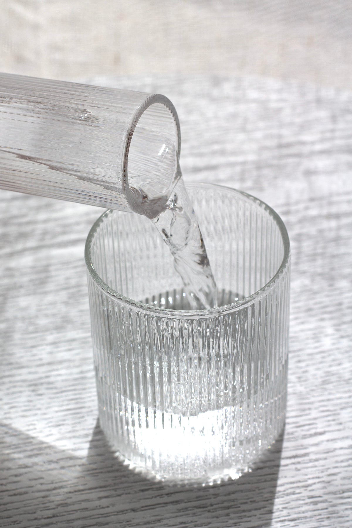 Water being poured into a fluted glass tumbler