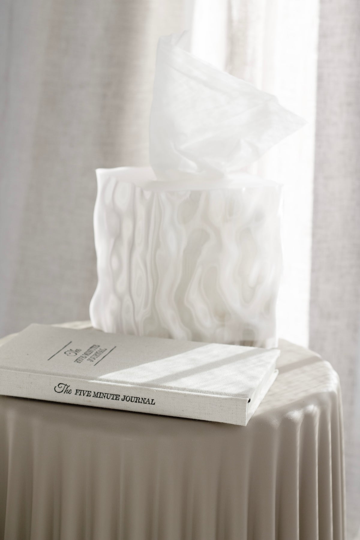 White Flow cover on a book on a ribbed side table in soft window light