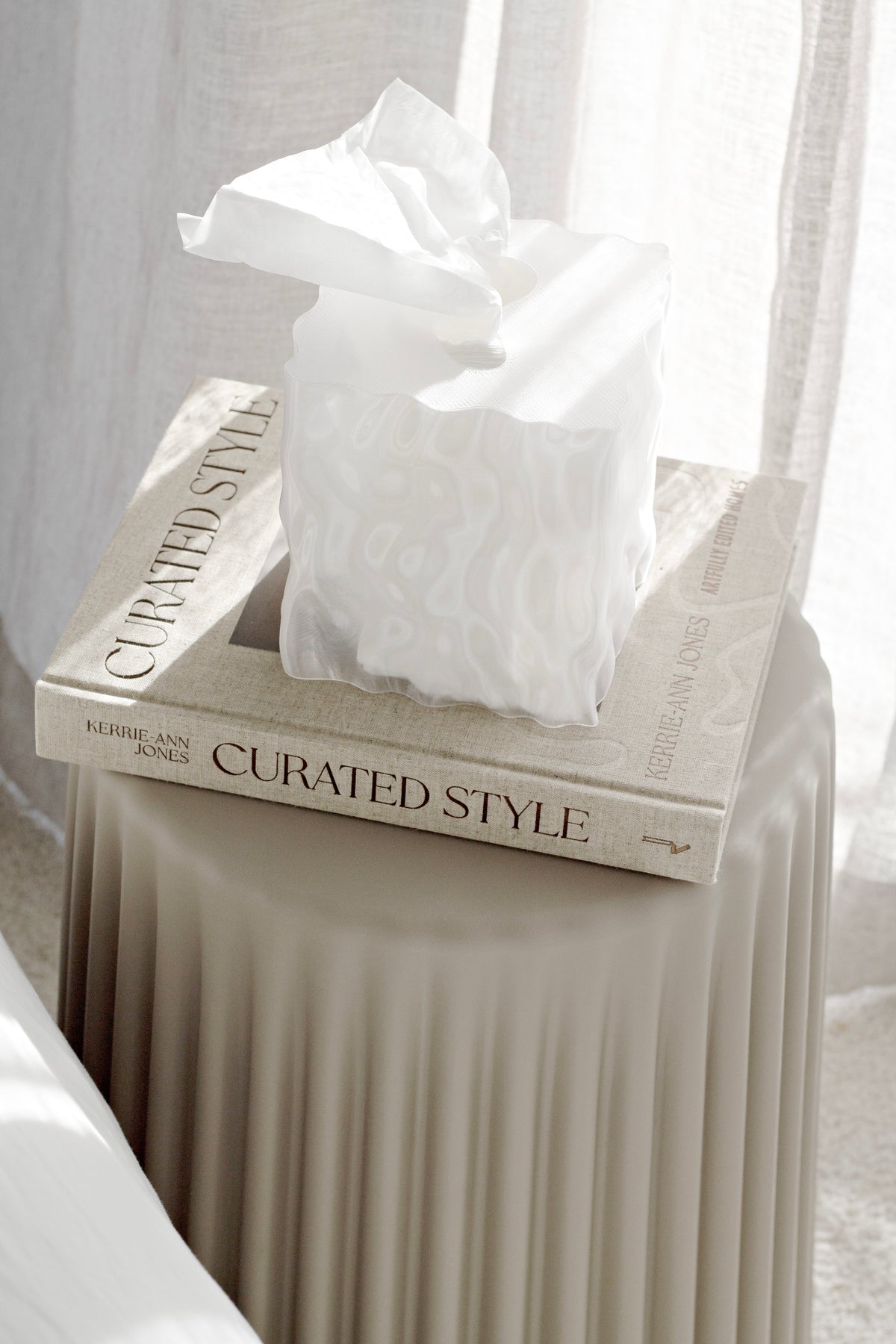 White Flow cover on a book stack on a ribbed side table