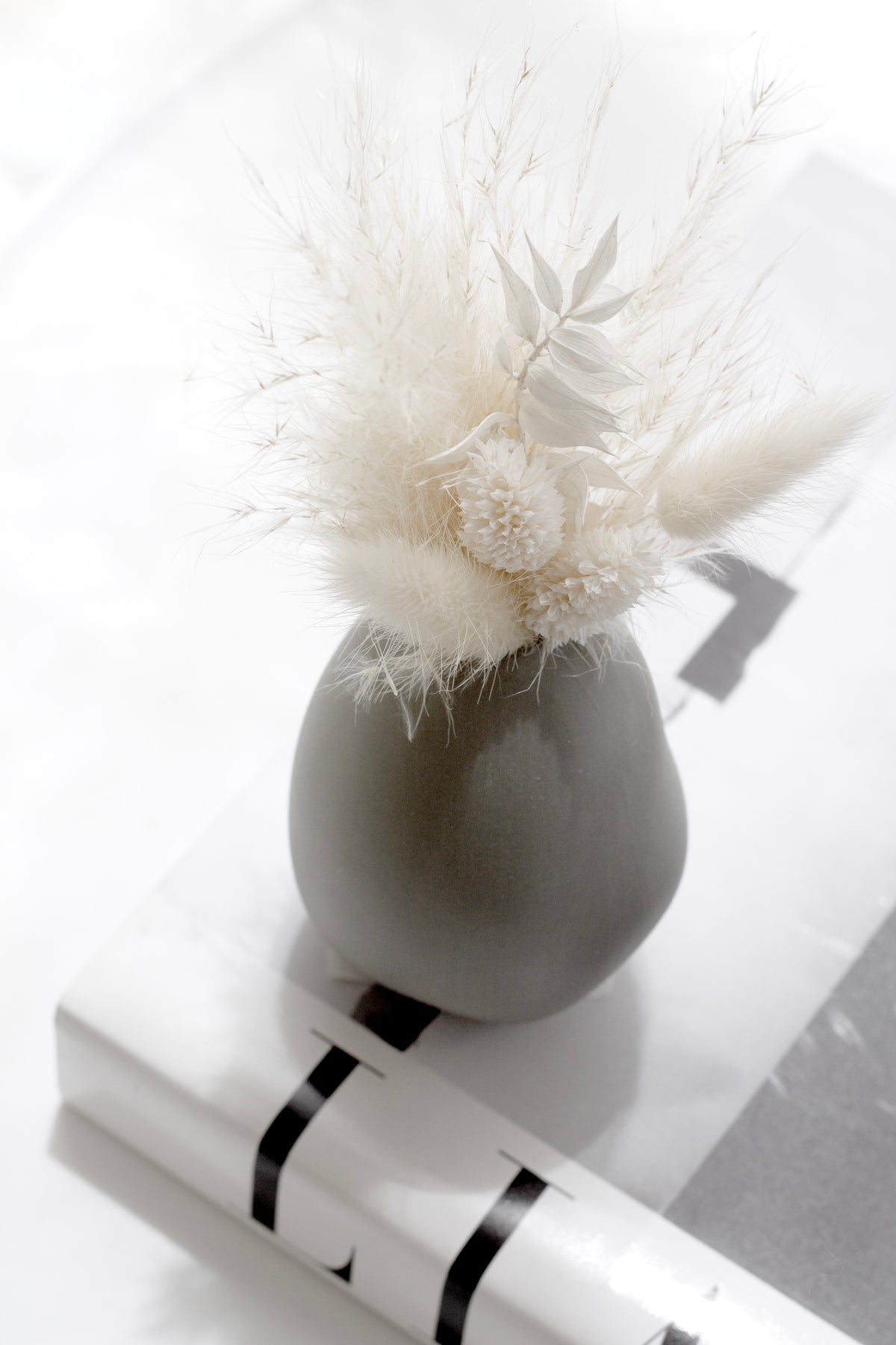 Harmie Vase Seed Grey styled on a tray with a candle