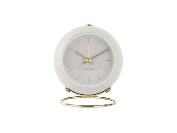 White Karlsson Globe alarm clock angled on its gold ring stand