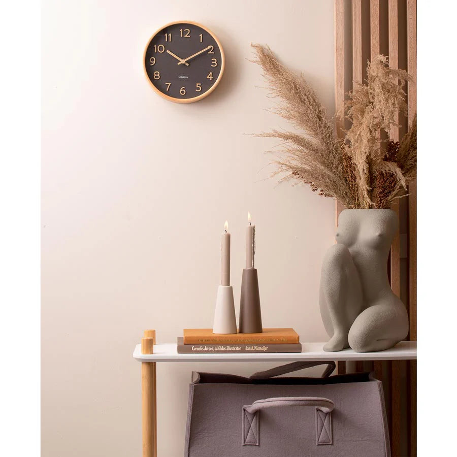 Karlsson Pure Wall Clock in black above a console with pampas grass and vases