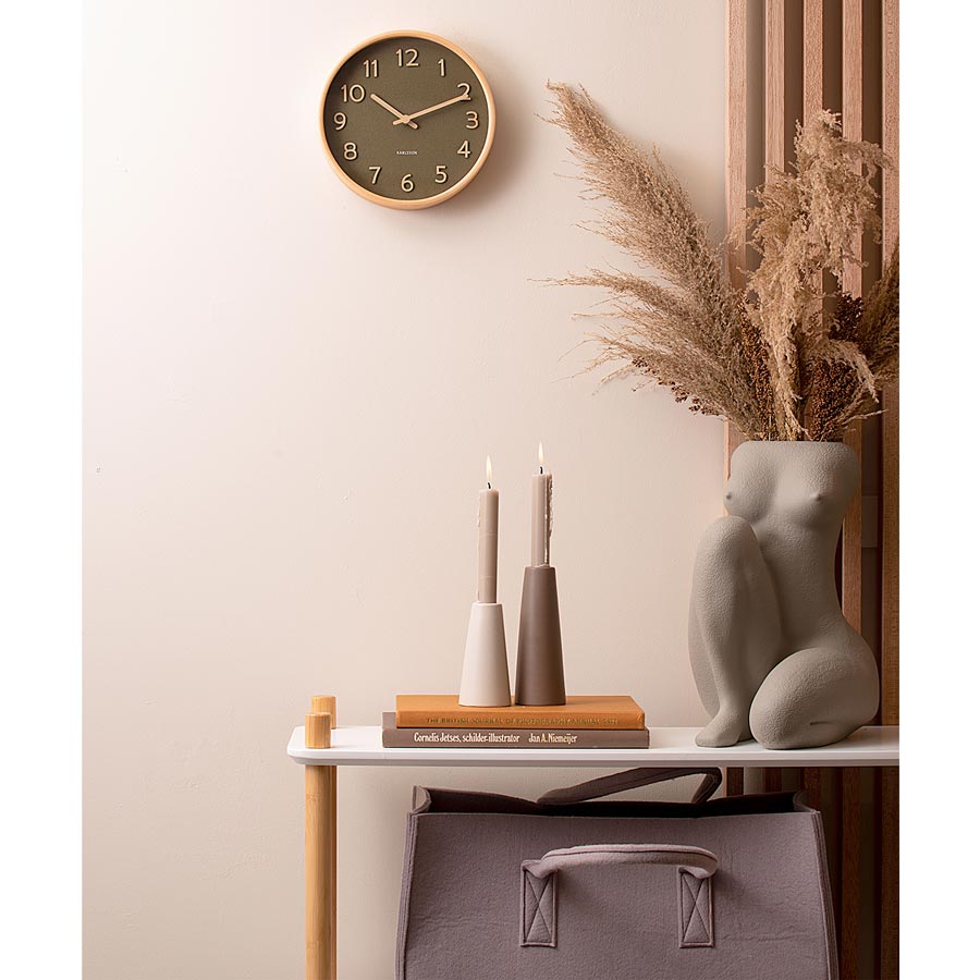 Karlsson Pure Wall Clock in moss green above a console with pampas grass and vases