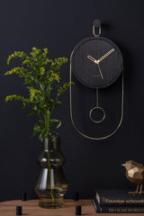 Black wood Swing pendulum clock styled on a dark wall