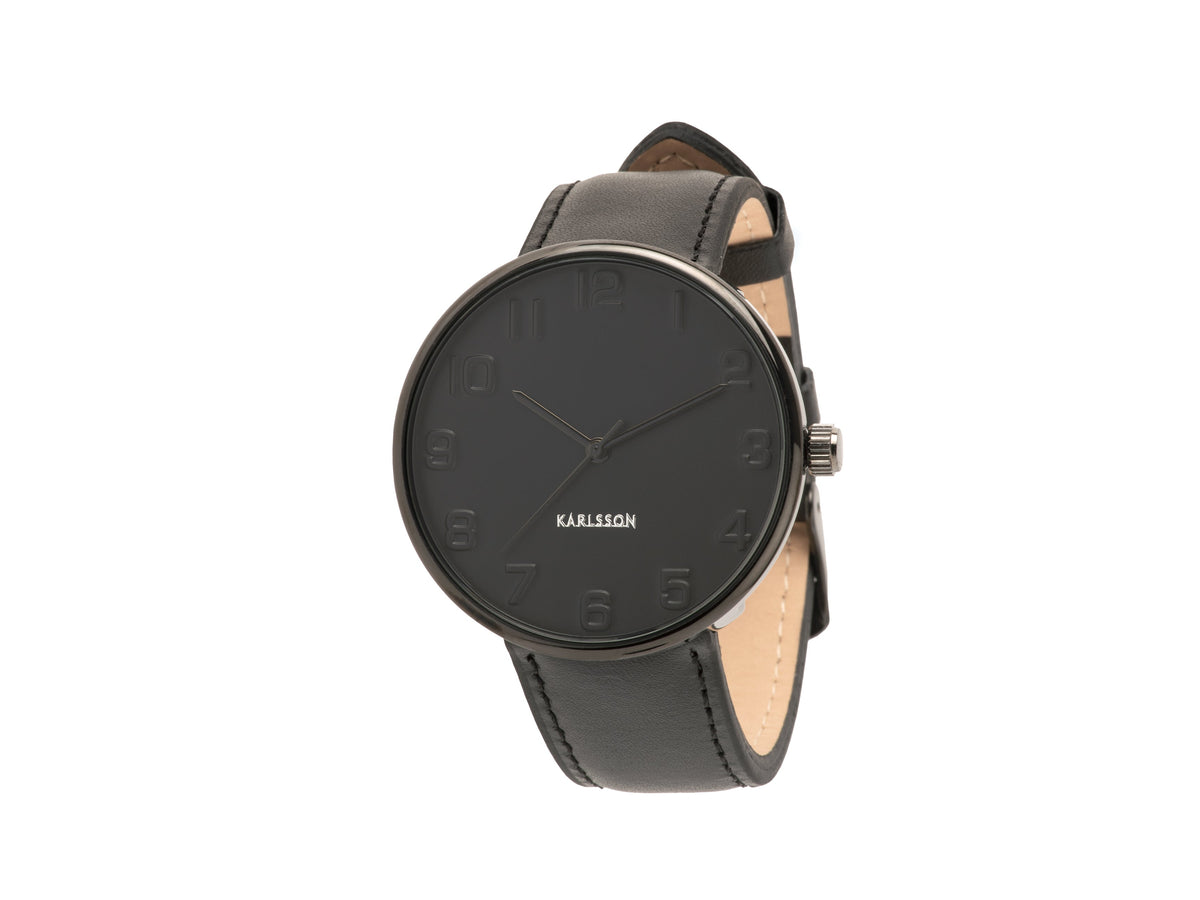 Karlsson Mr Black Steel watch with a black case and dark leather strap, shown at an angle