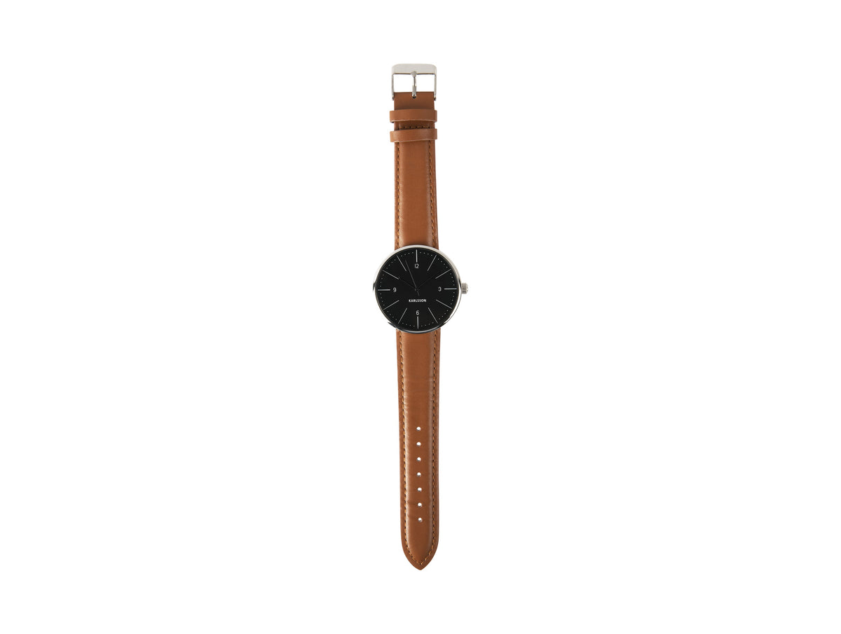 Karlsson Normann watch with a black dial photographed flat with the tan leather strap extended