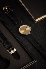 Karlsson Finesse women's watch with black case and gold dial on black leather strap