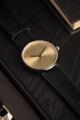 Karlsson Finesse women's watch with black case and gold dial on black leather strap