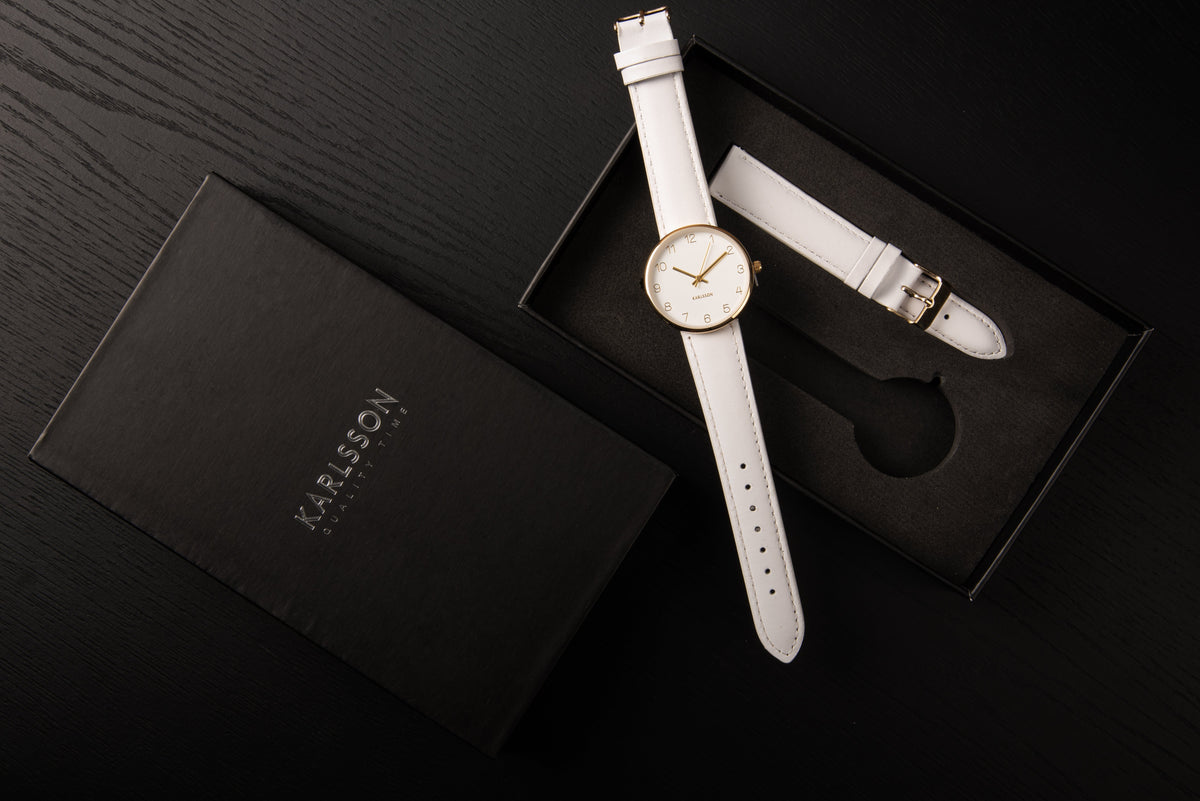 Karlsson Charm watch in its open gift box on a dark surface with the lid alongside