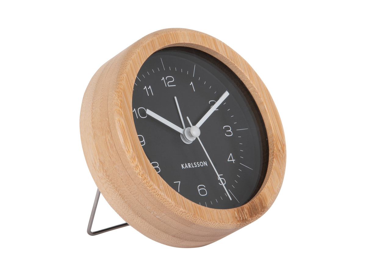Karlsson bamboo alarm clock with a black dial, angled on white