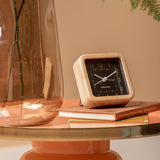 Black Neat Square bamboo alarm clock styled on a bedside table