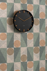 Black Grace wall clock styled on a patterned wall