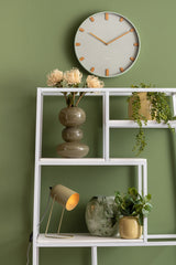 Grayed jade Grace wall clock styled on a green shelf unit