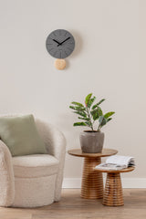 Dark grey Arlo pendulum clock styled on a living room wall