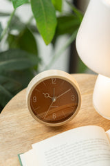 Caramel brown Monocle alarm clock styled on a shelf