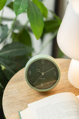 Jungle green Monocle alarm clock styled on a shelf
