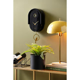 Black Tweet pendulum clock styled on a wall