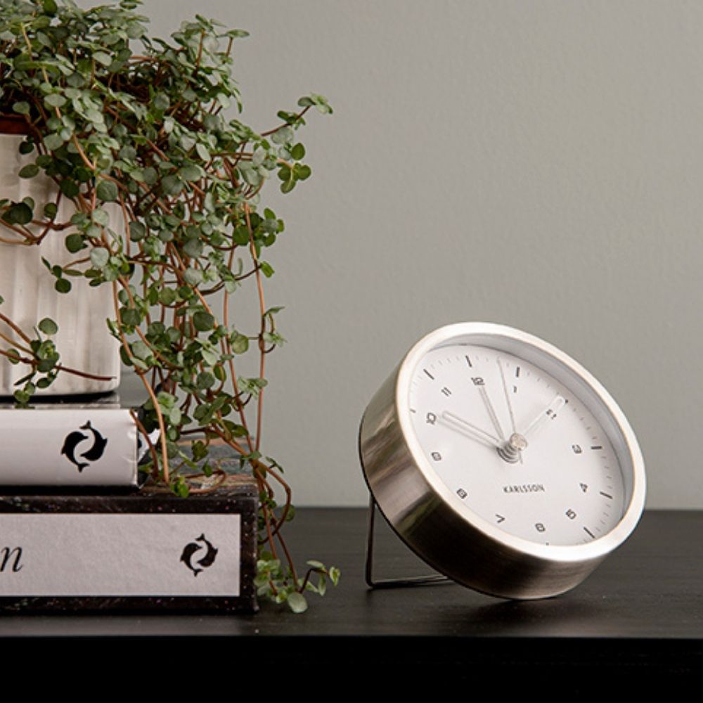 Karlsson Tinge Alarm Clock with brushed steel rim in white, styled on a bedside surface