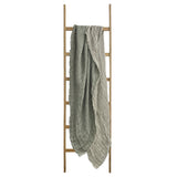 A Flux Home KENT THROW with a distressed eyelash edge hanging on a wooden ladder.