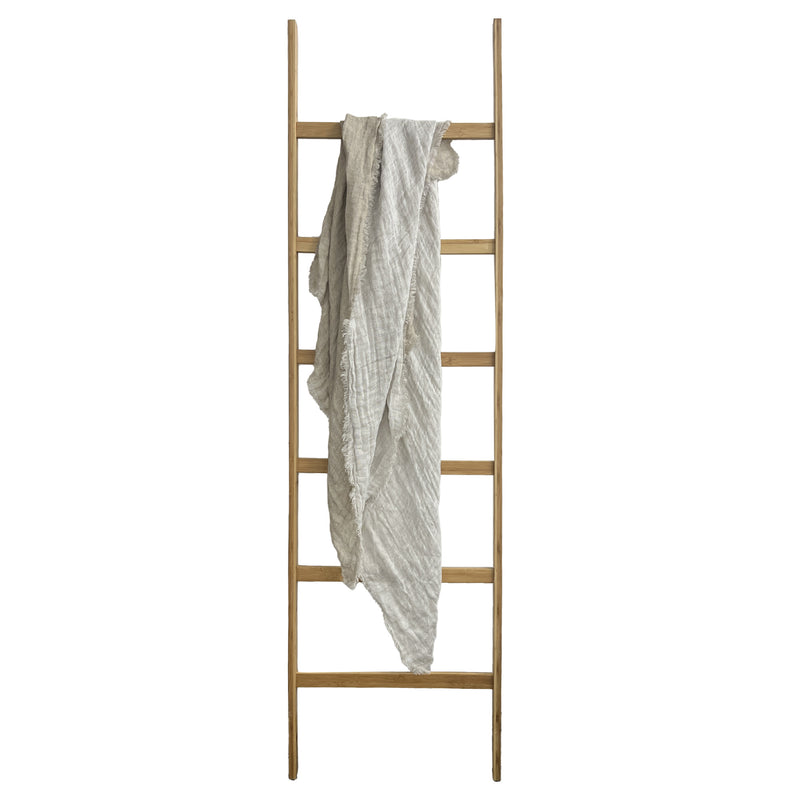 A wooden ladder with a Flux Home KENT THROW hanging on it.