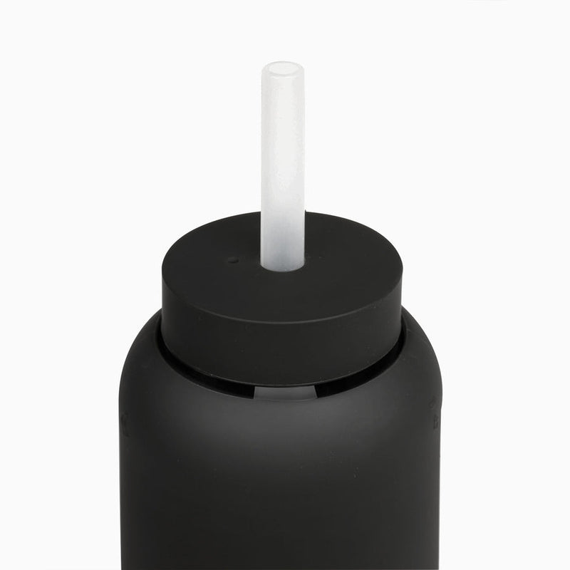 A black Day Bottle with Hydration Tracker - Various Options by Bink, with a plastic straw on top.