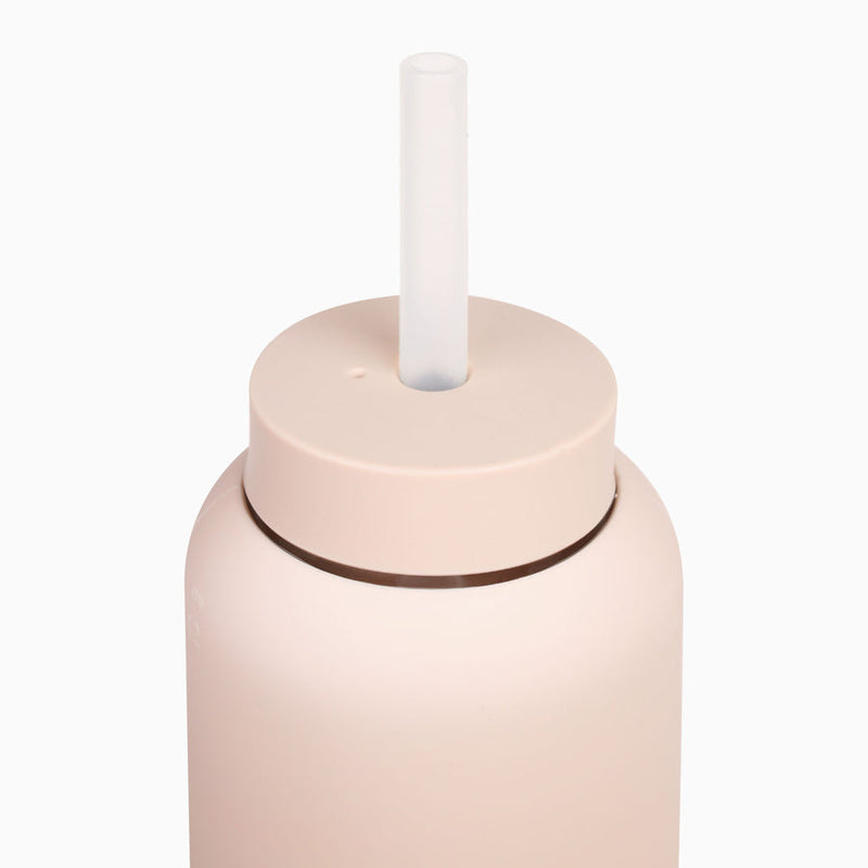 A Day Bottle with Hydration Tracker - Various Options by Bink, a pink glass bottle with a plastic straw designed for daily recommended water needs.