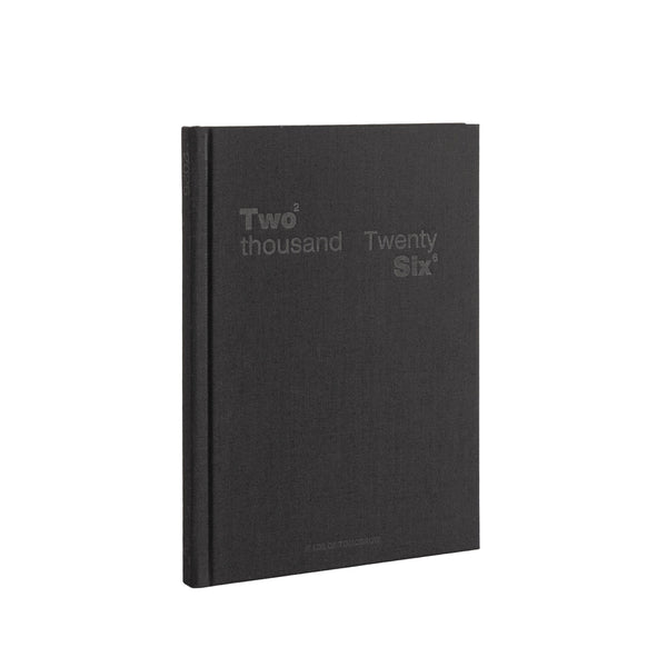 Black notebook with 'Two thousand Twenty Six' text on a white background