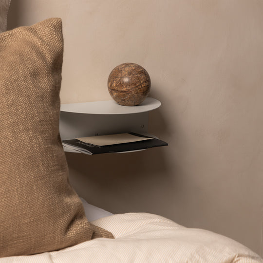 FOLD Bedside Table Mini beside linen cushions with a stone ball and a book