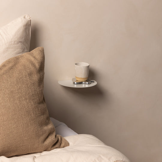 FOLD Round Shelves in black mounted on a wall styled with a small plant