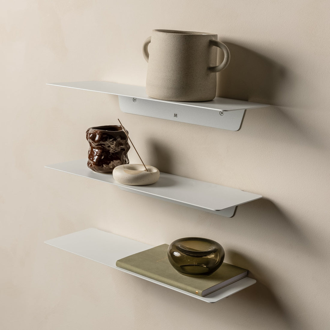 Three white FOLD Ledges stacked with a mug, a ceramic vase and a small dish