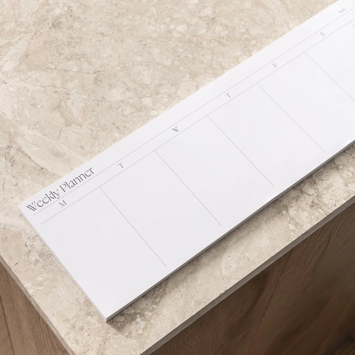 Weekly Desk Strip laid flat above a keyboard by Made of Tomorrow