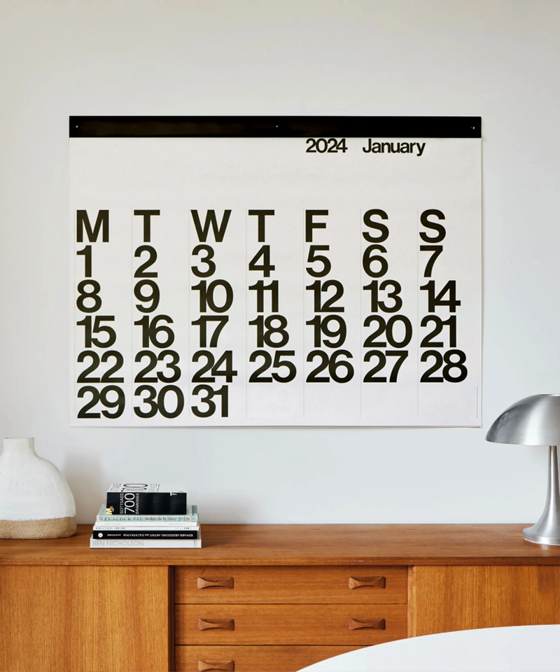 A 2024 Stendig Calendar - PREORDER hanging above a desk.