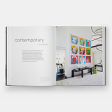 An open LANGUAGE OF HOME: THE INTERIORS OF FOLEY & COX book with contemporary art on the cover.