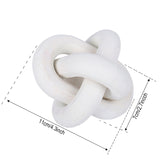 A Flux Home white wooden toy with a Wooden Knot Ornament on it.