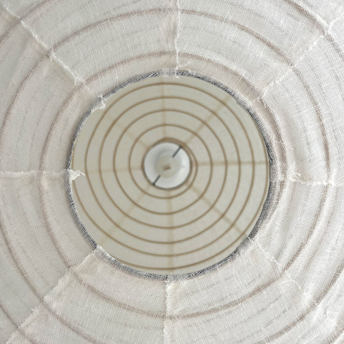 Close view of the pendant shade's ribbed linen structure from below