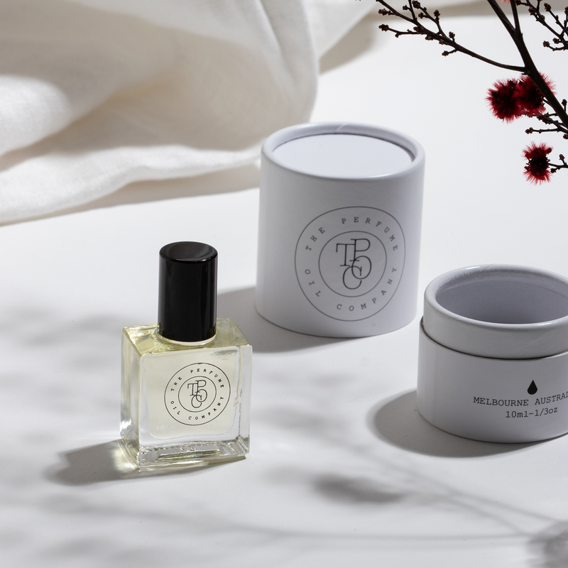 A The Perfume Oil Company ROUGE perfume bottle and fragrance box on a white table.