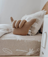 Tan bunny soft toy and a check cushion on the dune palm fitted sheet
