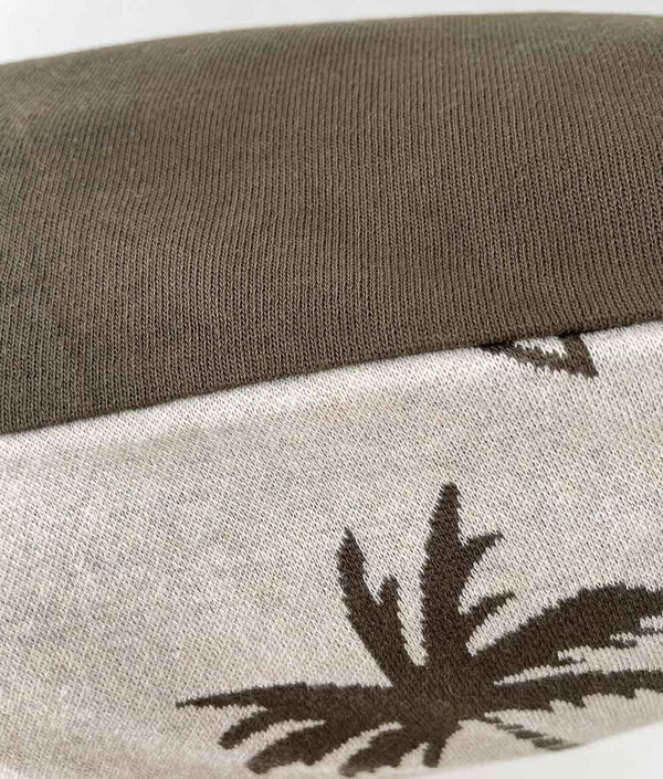 Close-up of the Surfing Palm kids pillowcase edge, the olive reverse folded over the natural palm print side