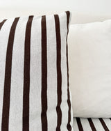 Close-up of the chocolate and ivory striped euro pillowcase beside a plain ivory pillow