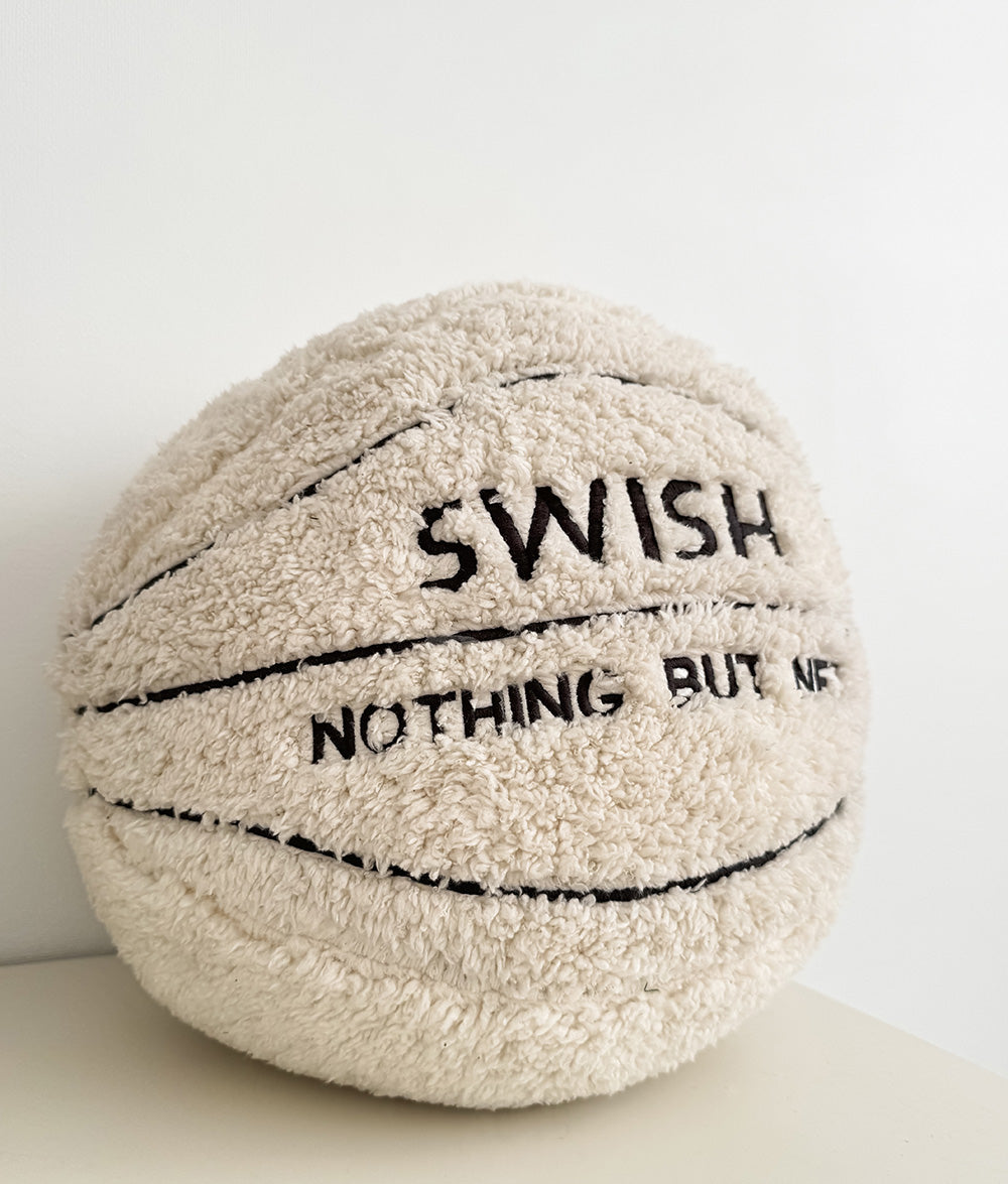 Cream sherpa basketball cushion with Swish Nothing But Net lettering on a plain white surface