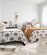 Wide view of a shared kids room with palm print bedding and the basketball sherpa cushion