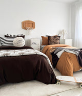Boys bedroom with two beds, a skateboard on the floor and the basketball sherpa cushion on the bed