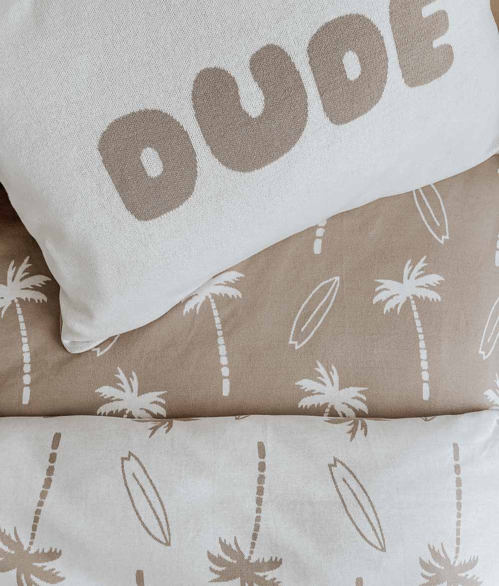 DUDE pillowcase on a sand Surfing Palm fitted sheet above a natural Surfing Palm kids duvet cover