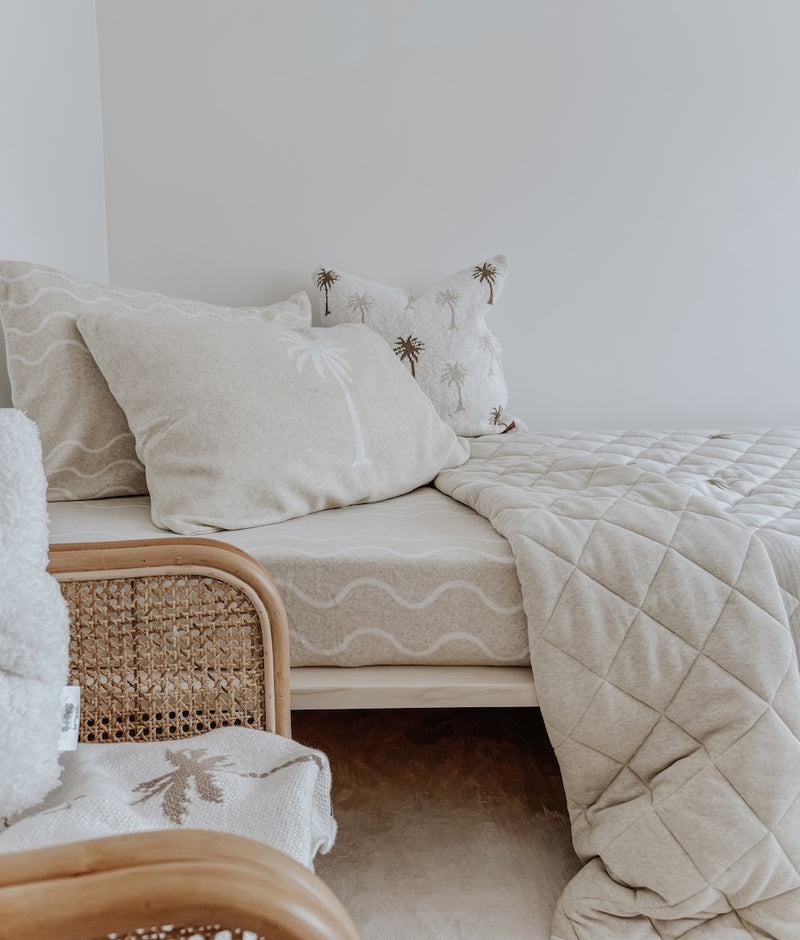 Palma palm cushion on a kids bed with a Coastal Marle fitted sheet, greige quilt and rattan chair