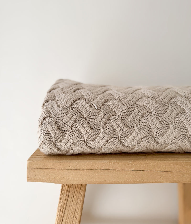 Close view of the raised wave knit texture on the folded Greige Wave throw