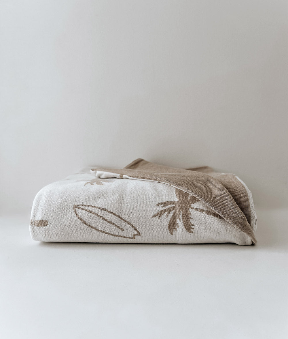 Folded Surfing Palm kids duvet cover in natural with sand palm and surfboard print on a white backdrop
