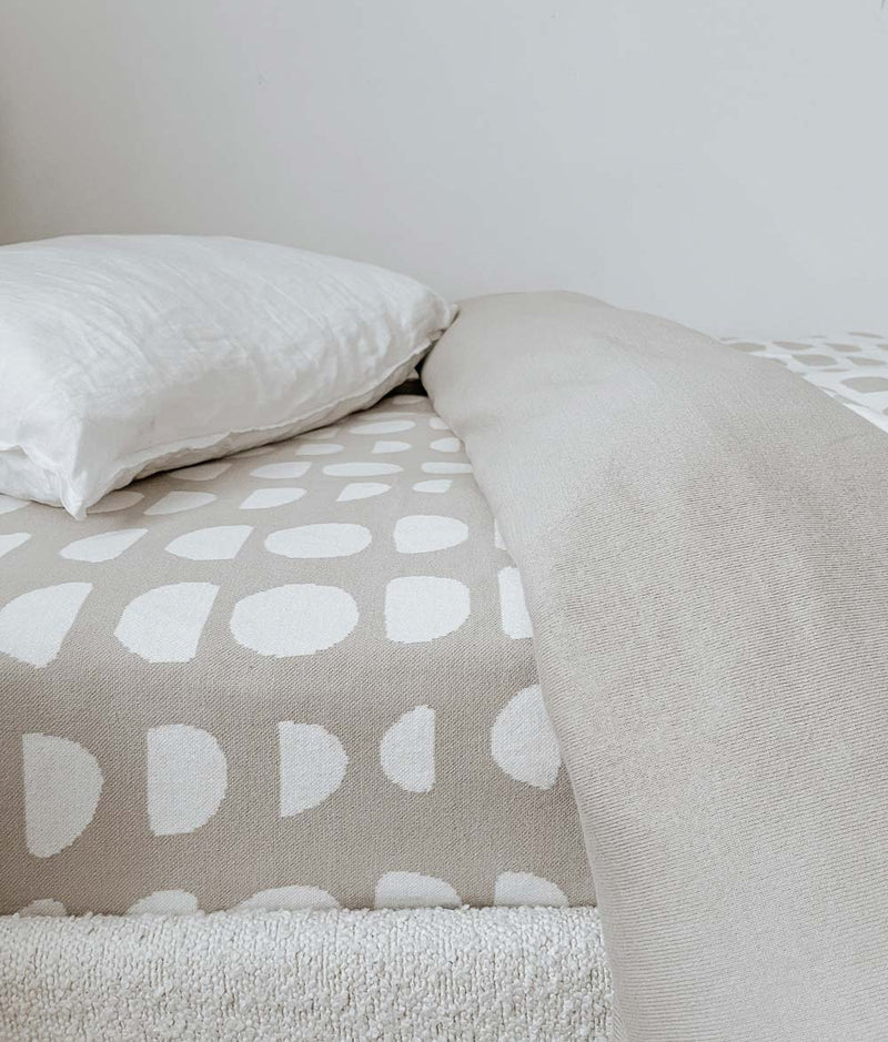 A bed with a white and beige JERSEY COTTON SHEET - MOON PHASE duvet cover by Bengali Collections.