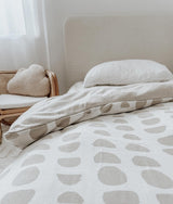 A bed with a white and beige Moon Phase duvet cover from Bengali Collections.